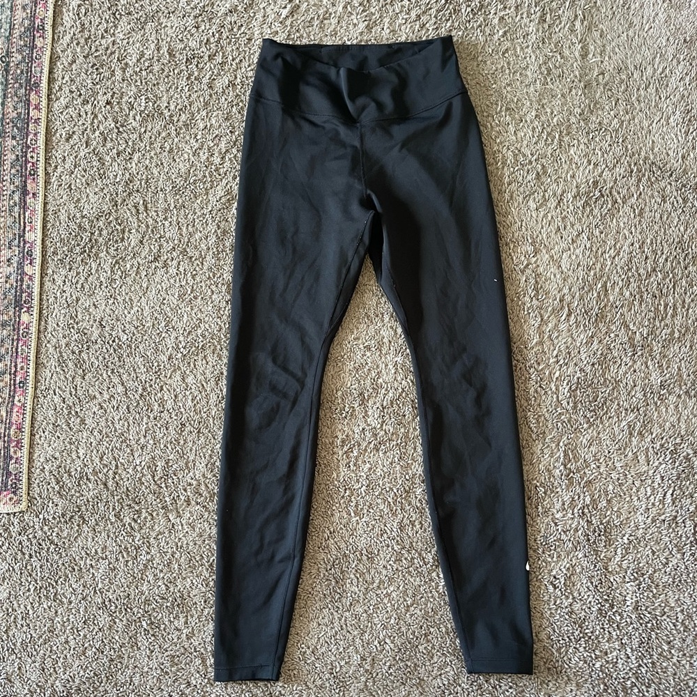 Black athletic Nike leggings with small emblem on the lower left calf